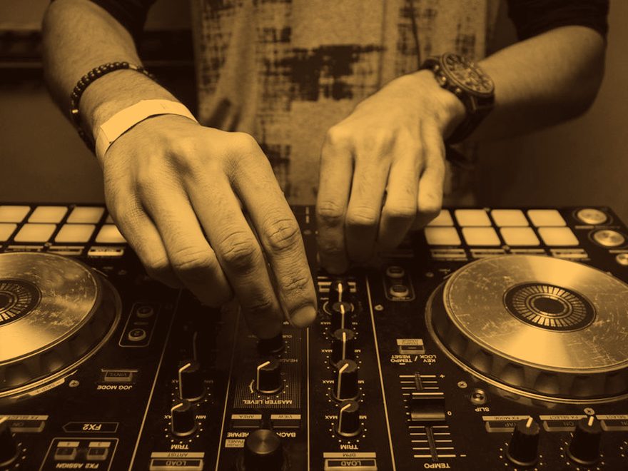 Mãos operando uma controladora de DJ